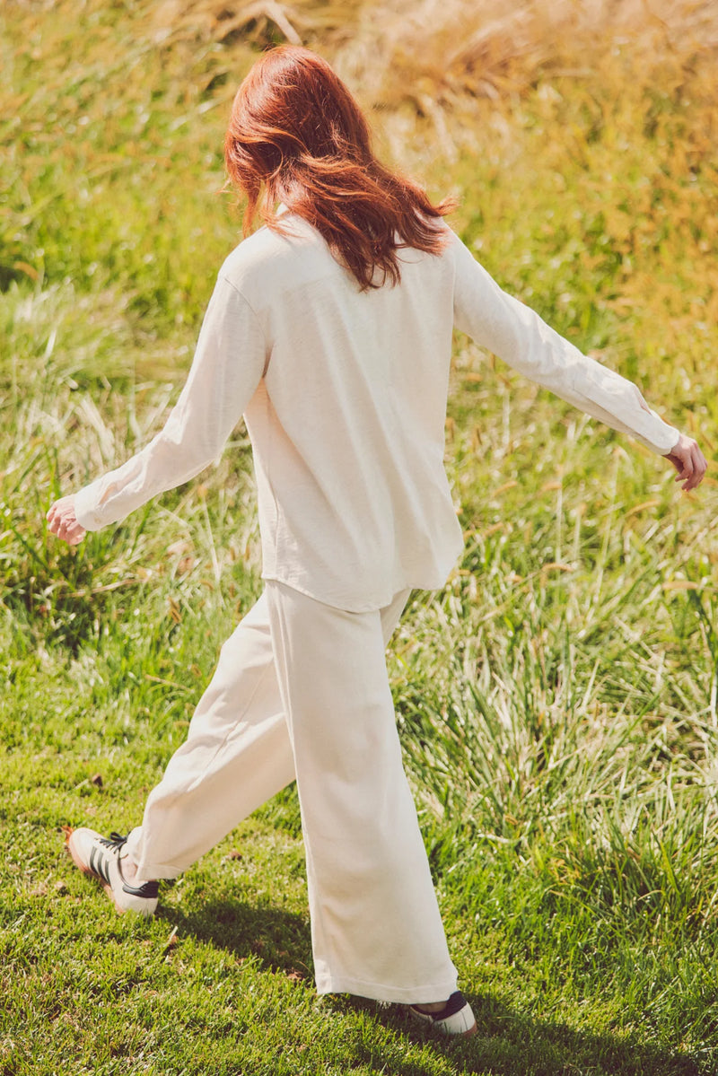 a woman in a cream button-down and wide-leg pants