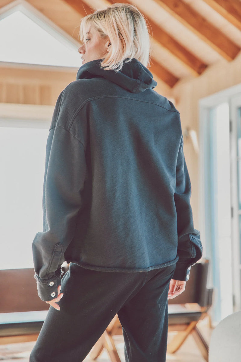 Back view of a woman in a black Dartmouth Jacket layered over a hoodie