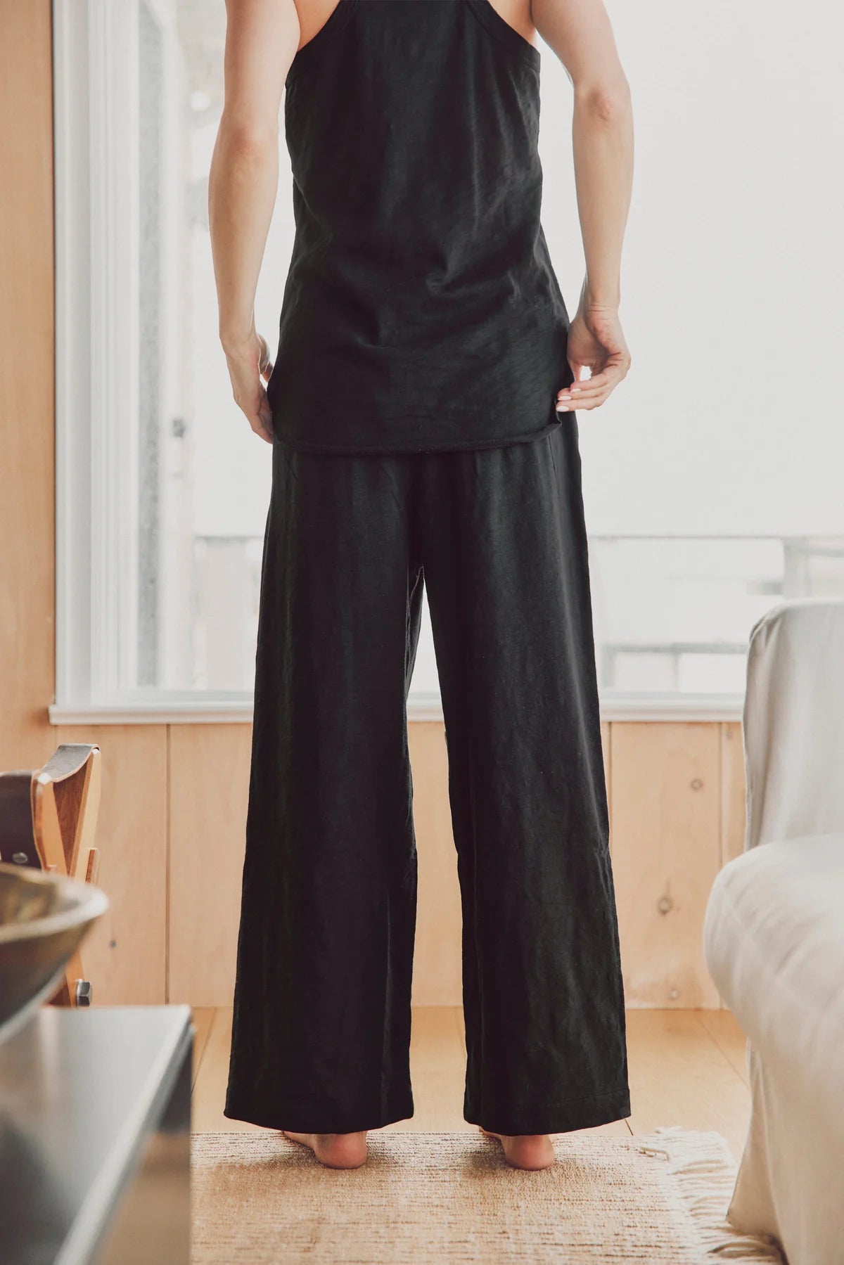 model in black top and black wide-leg pants