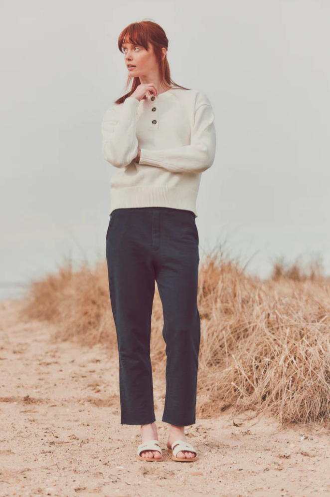 model wearing cream-colored sweater with navy pants