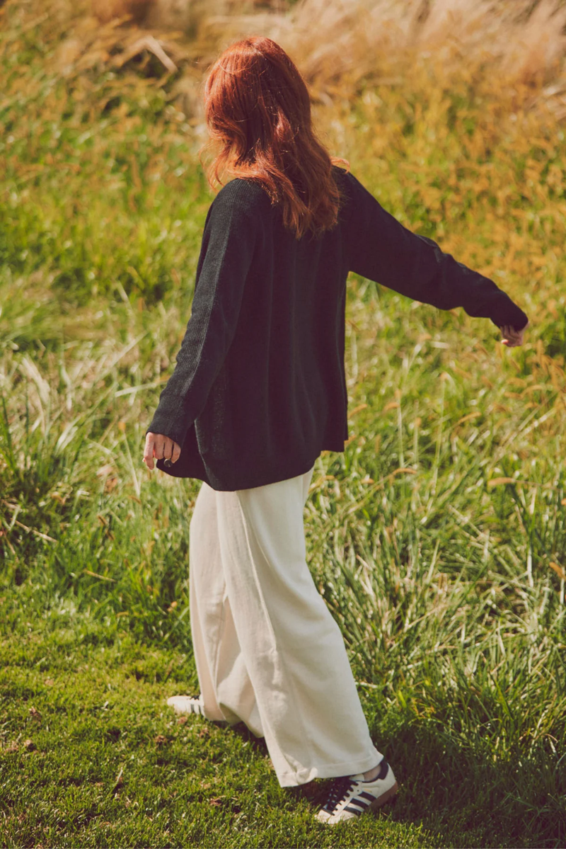 a model facing away from the camera in a black cardigan