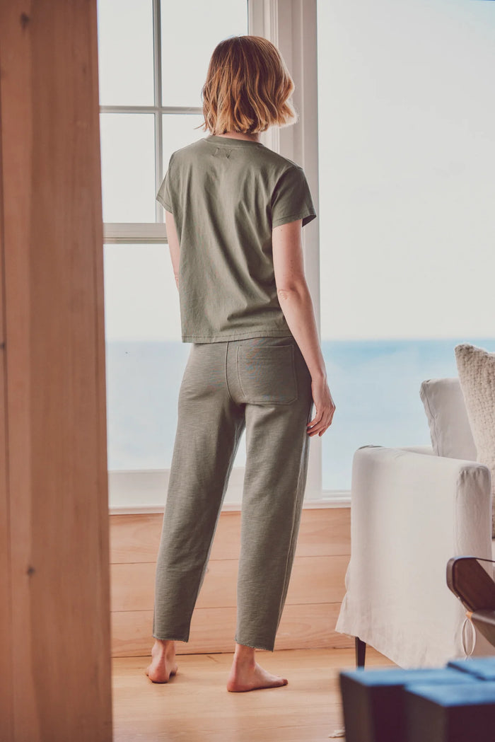 a model facing away from the camera in a green tee and pants