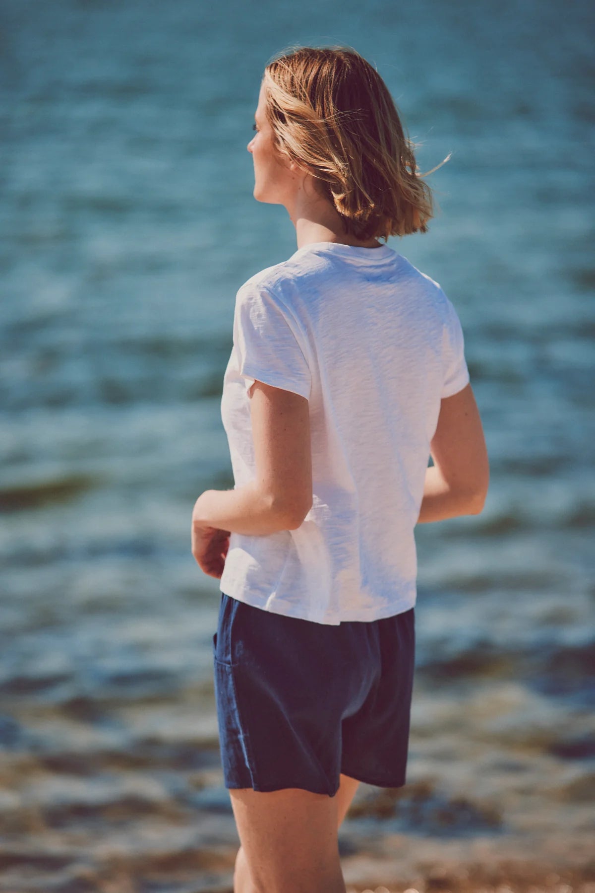 a model facing away in a white tee and shorts