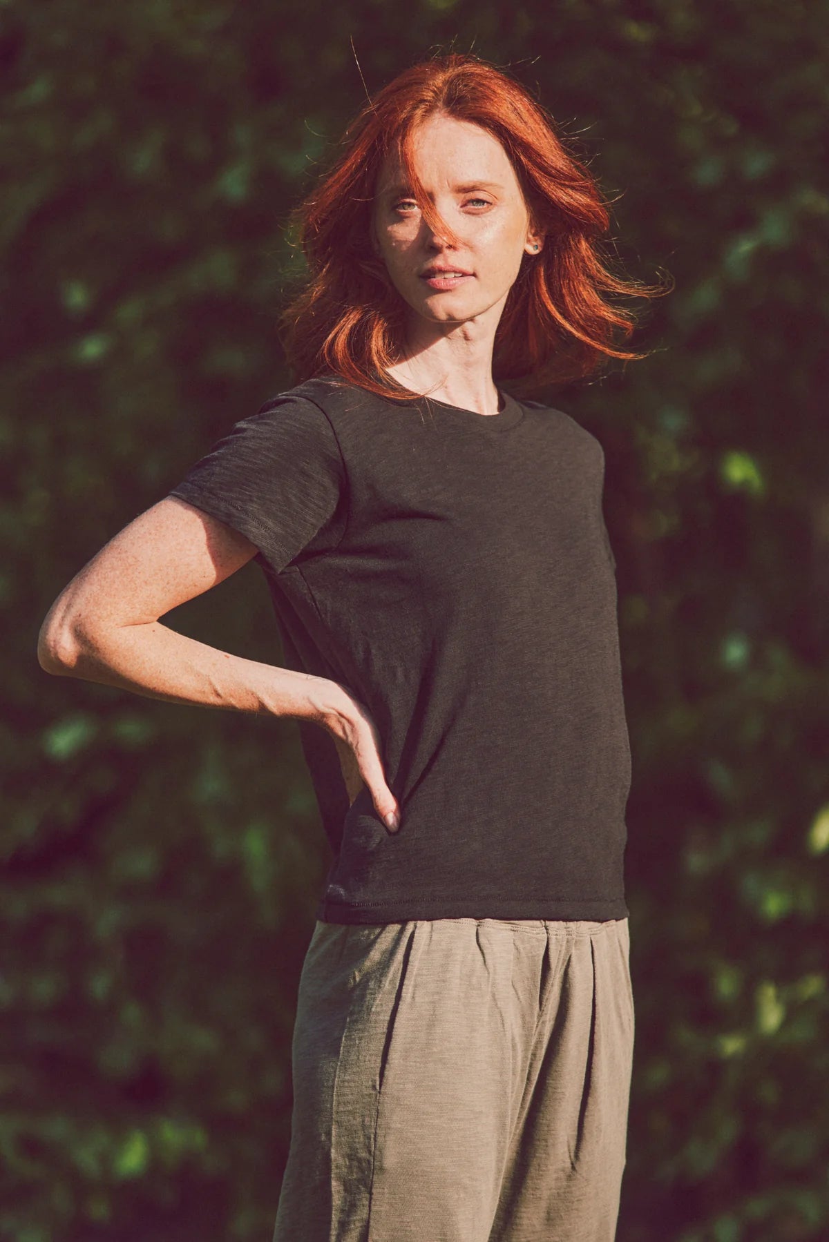 model with hands on hips in black tee