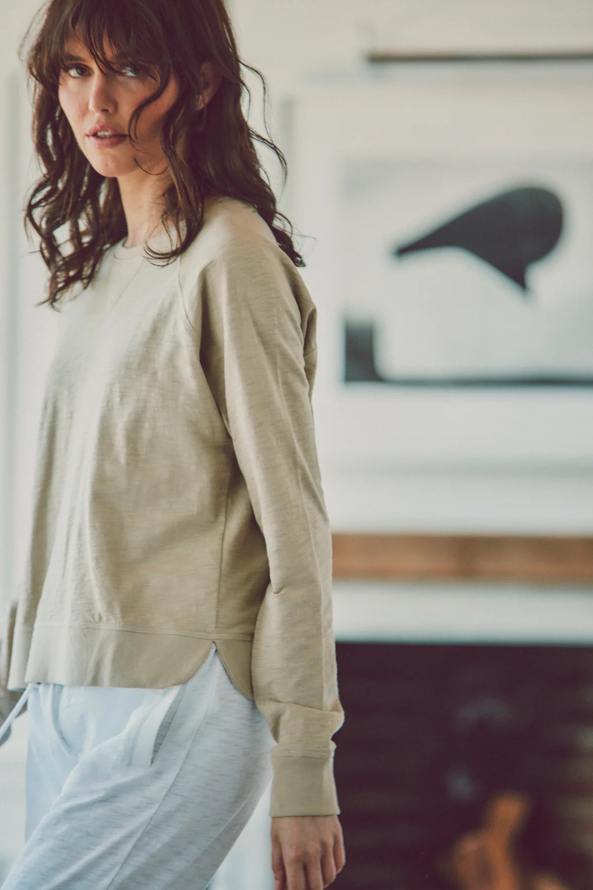 a model in a beige long-sleeve tee