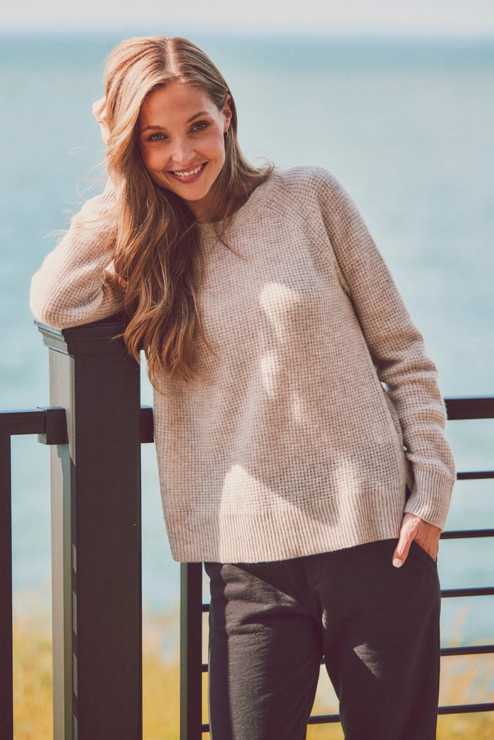 a model in a beige sweater