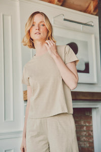 a model in a beige tee and pants