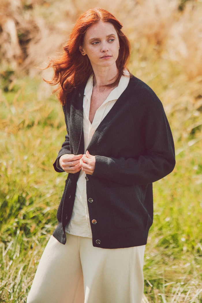 a model in a black cardigan and white top