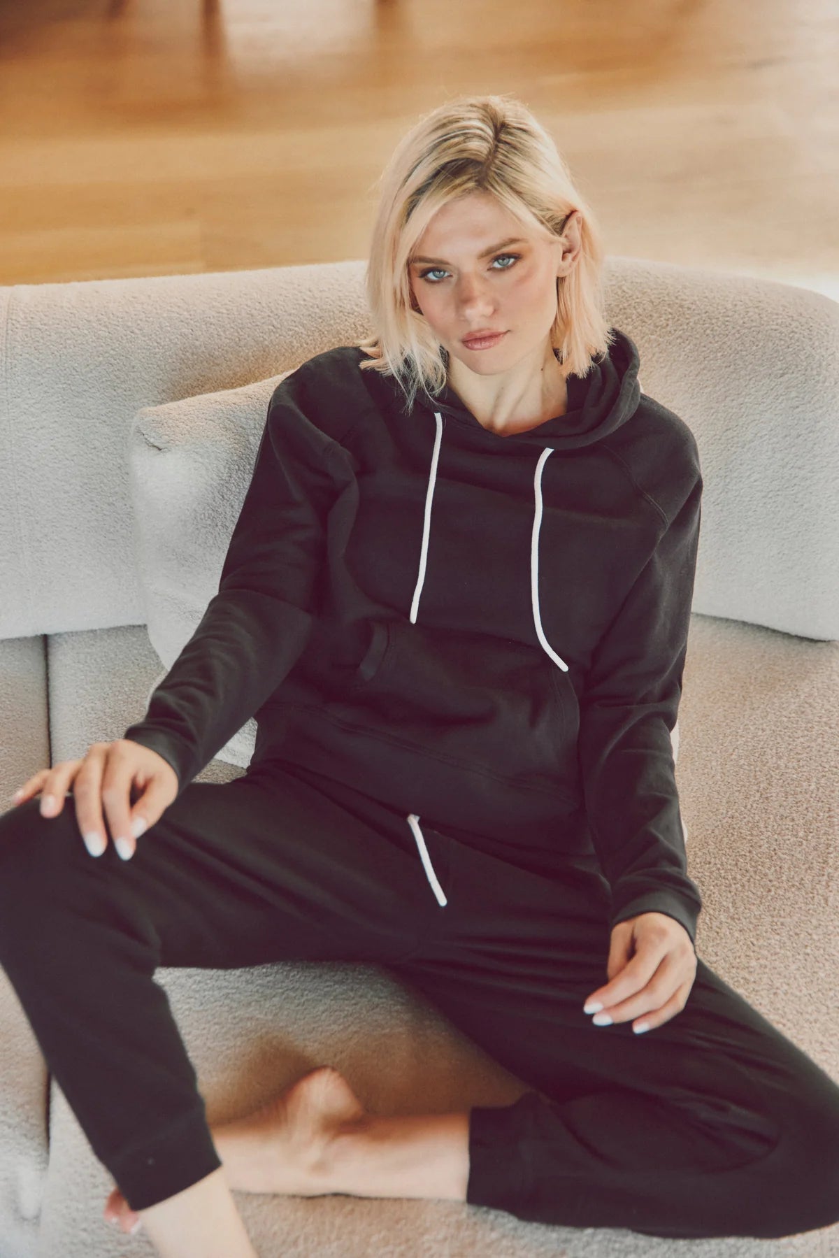 a model in a black hoodie and joggers