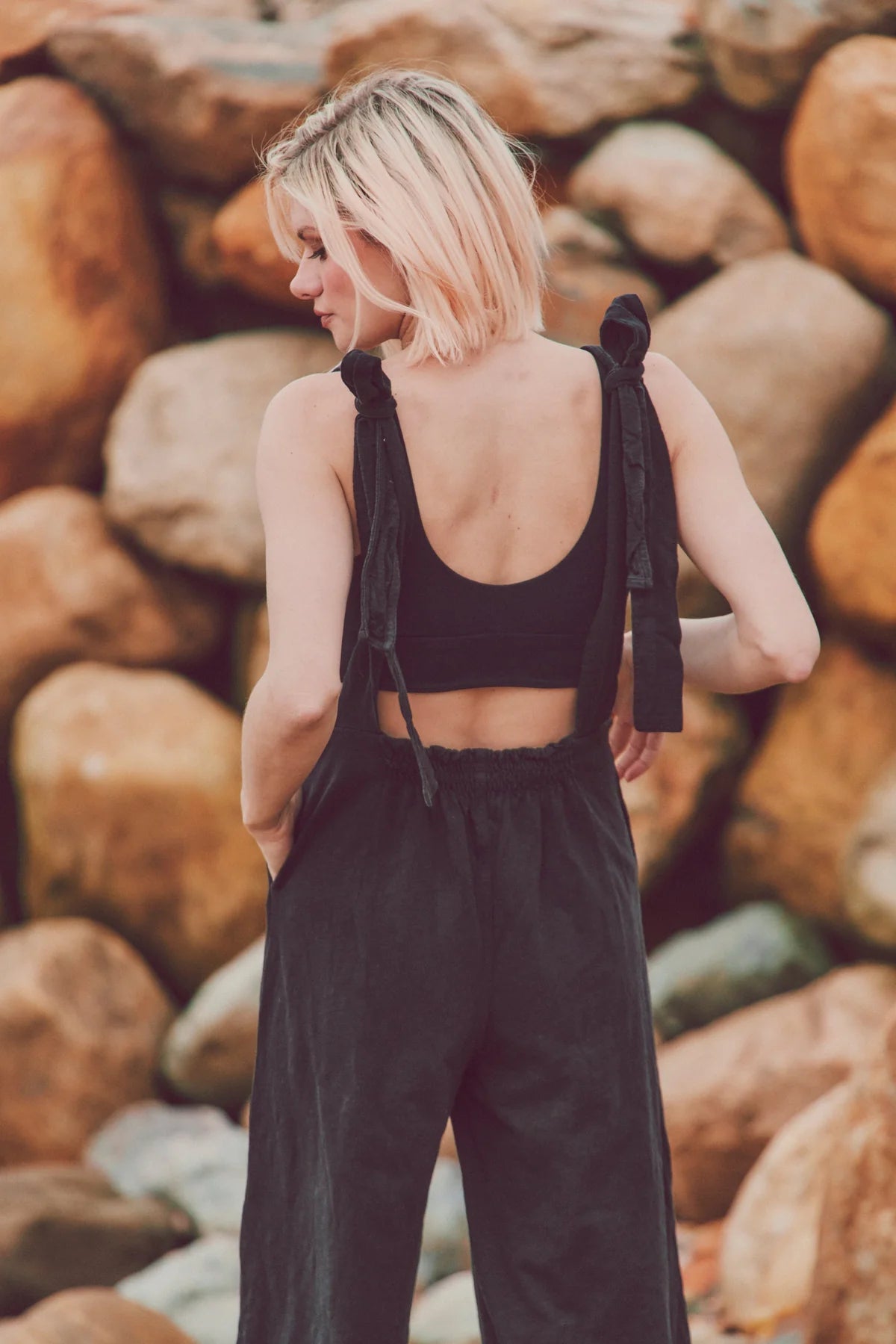 a model in a black jumpsuit