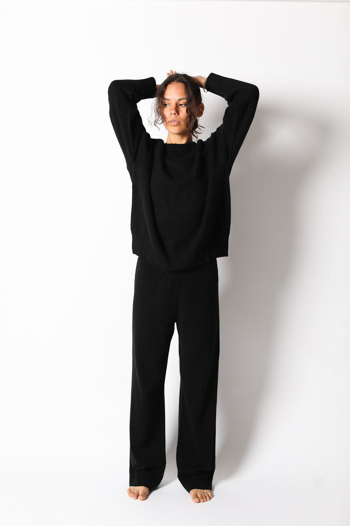 a model in a black sweater and cashmere pants