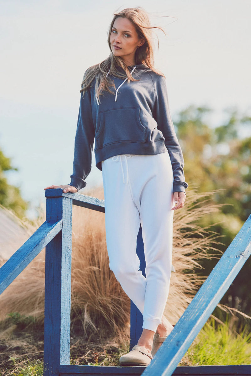 a model in a blue hoodie and white pants