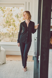 a model in a black cashmere button-up and pants