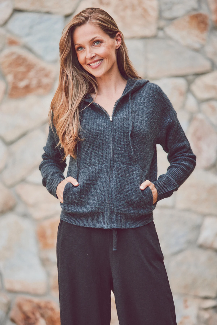 a model in a charcoal hoodie and black pants