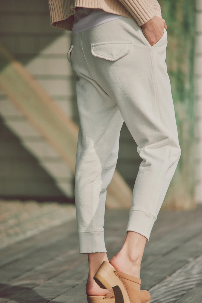 a model in beige clog shoes and white joggers