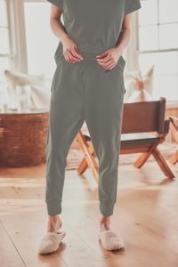 a model in a gray shirt and joggers with slippers