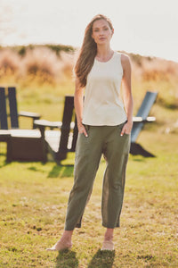 a model in green cotton pants and a white tank