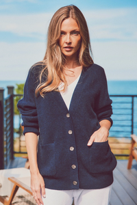 a model in a navy cardigan with hand in pocket