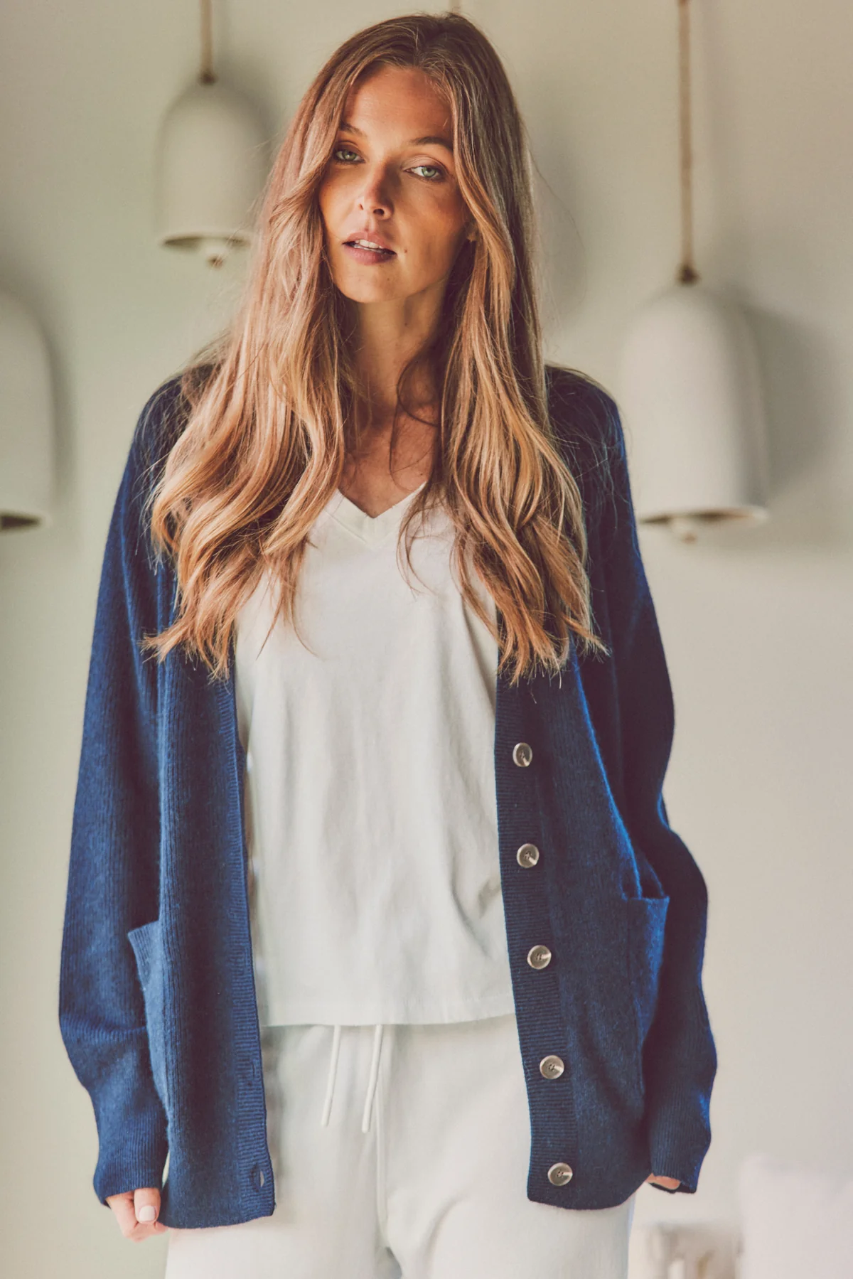 a model in a navy cardigan and white tee