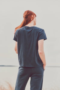 a model facing away from the camera in a navy tee and pants