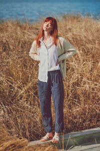 a model wearing navy cotton pants and a white shirt