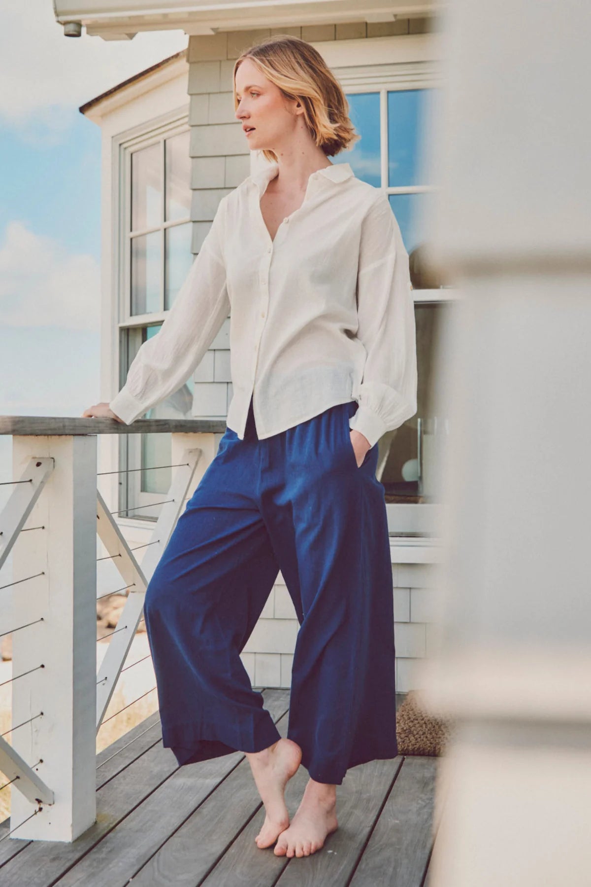 a model in a white shirt and blue culotte pants