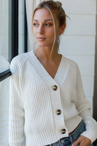 a model in a white three-button cardigan