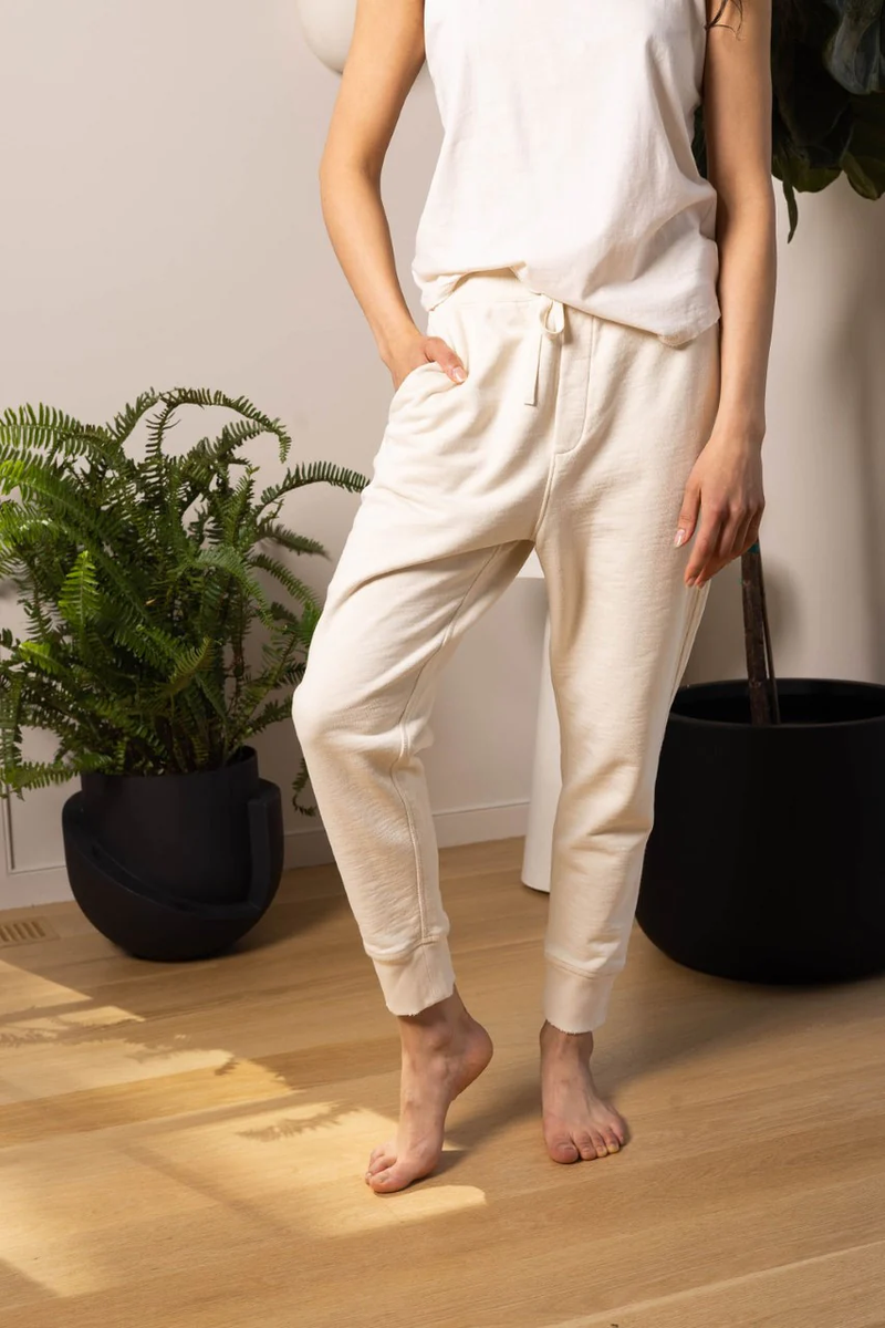 a model barefoot in white joggers and a t-shirt