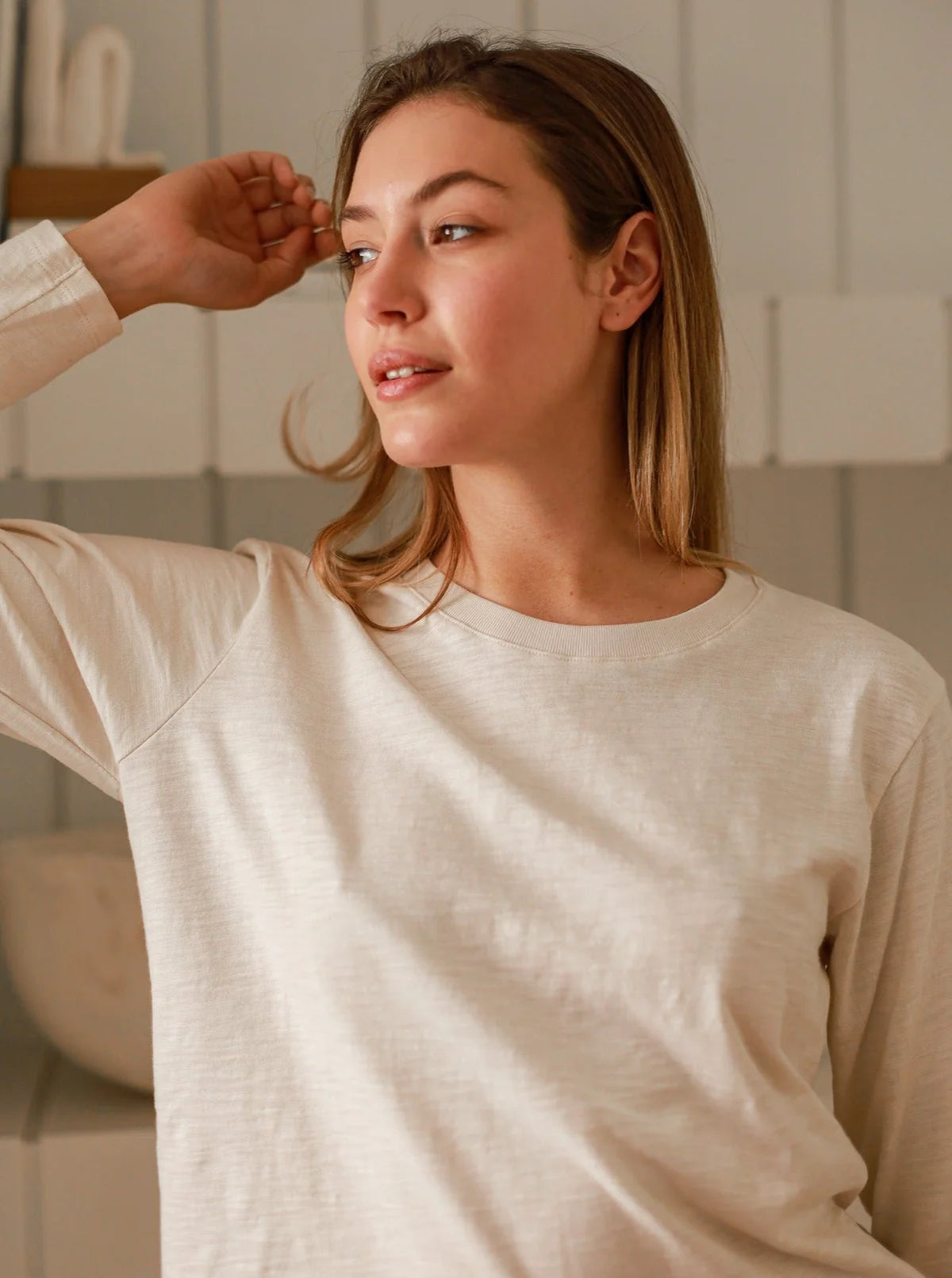 a model in a white long-sleeve tee