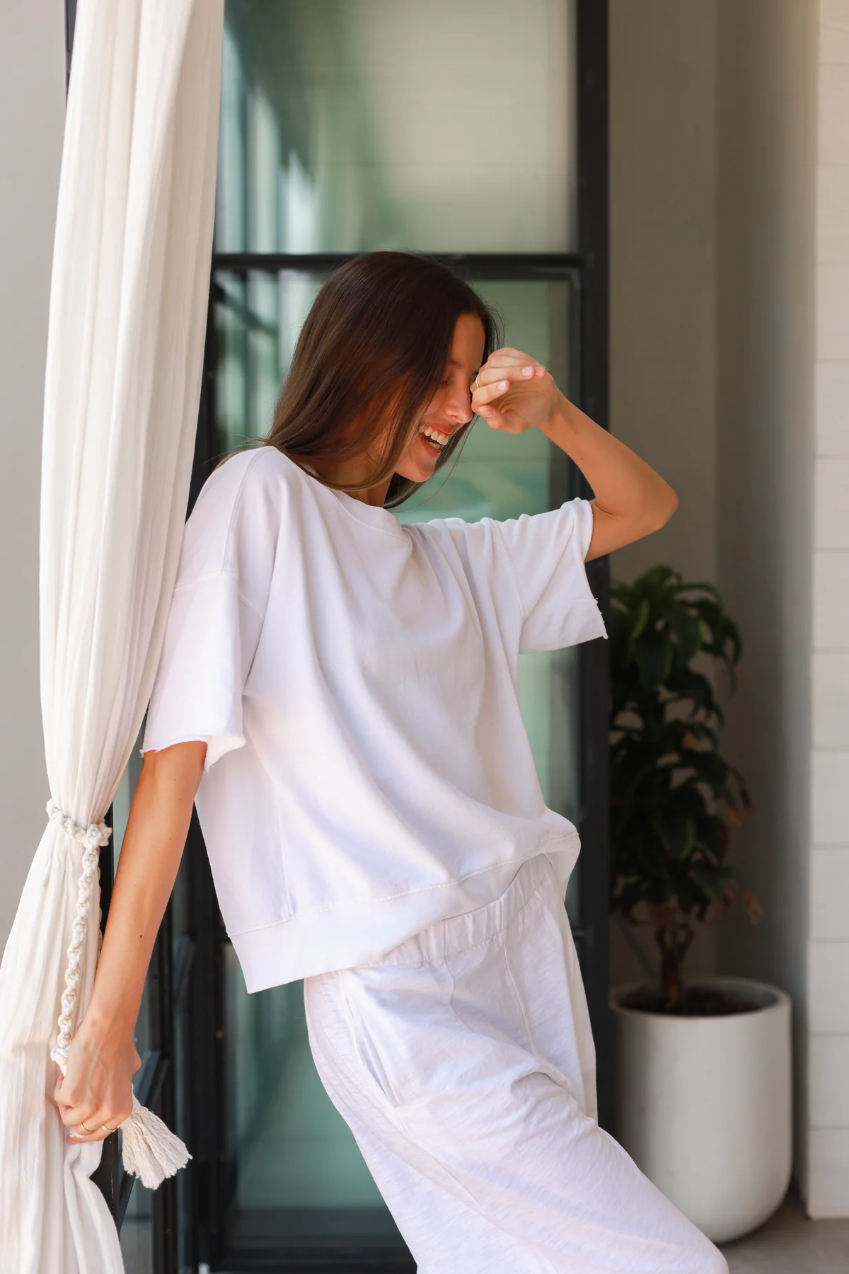 a model in white pants and a white t-shirt