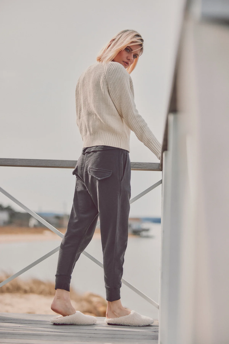 a model in a white sweater and navy joggers