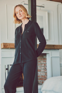 a model leaning on a post in a cashmere loungewear set