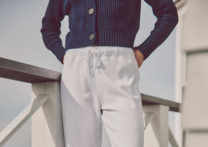 model wearing a navy cardigan with white loungewear bottoms