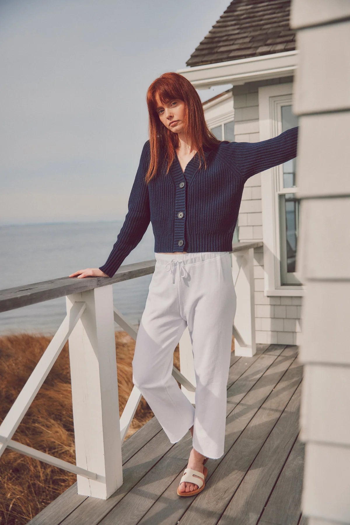 model wearing a navy cardigan with white pants