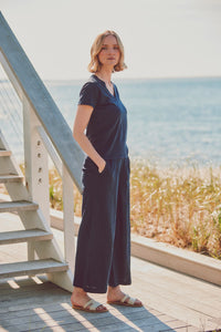 model posing in navy matching casual wear set next to the ocean