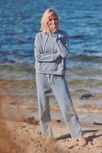 a model on the beach in a blue jogger set