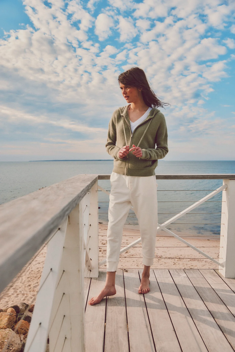 a model on a deck in a green hoodie