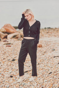 a model outside in a black cardigan and black pants