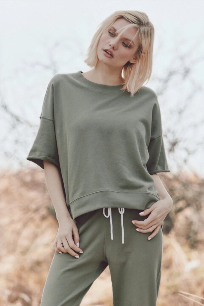 a model outside in a light green t-shirt and joggers