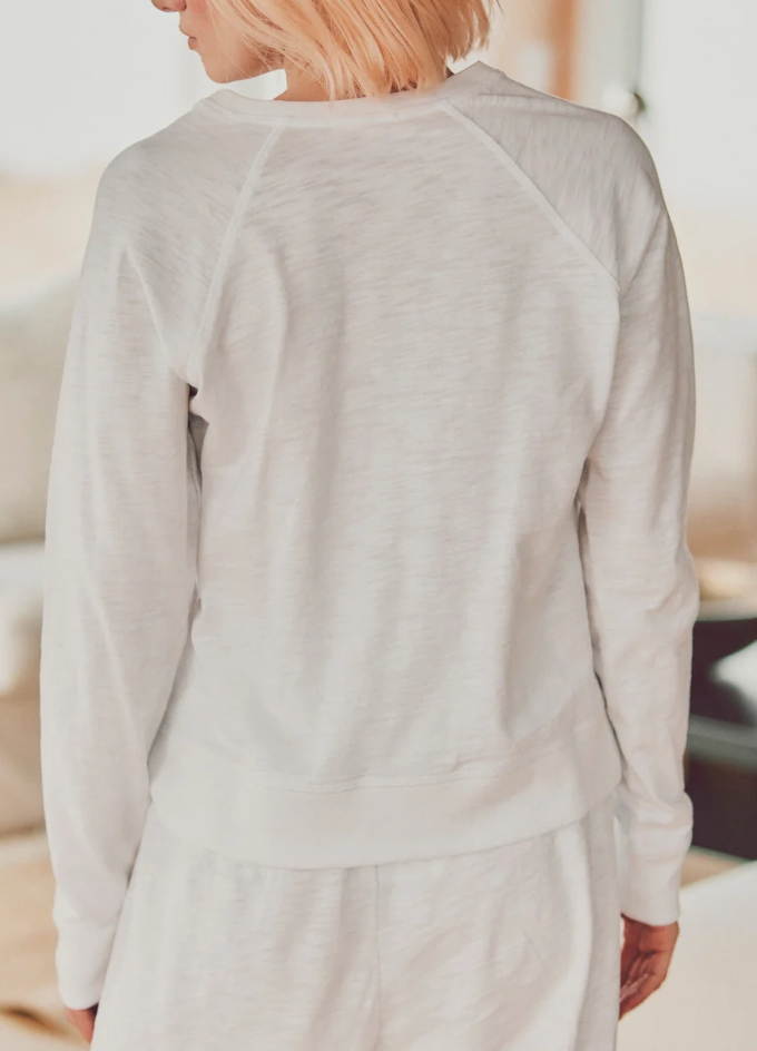 a model showing the back of a white long-sleeve