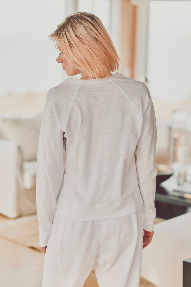 a model showing the back of a white long-sleeve and pants