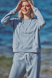 a model smiling in a blue jogger set