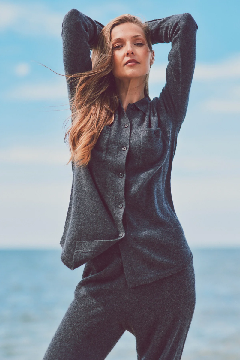 a model with arms raised in a cashmere button-up