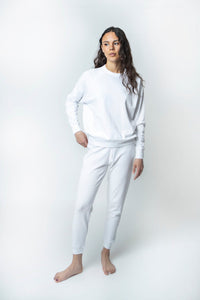 studio model reaching in pocket in a white matching sweat set