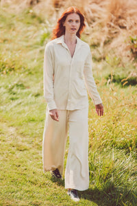 Woman in a cream button-down and wide-leg pants